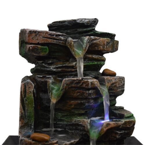 Primer plano de la fuente de agua cascada mostrando las luces reflejadas en el agua